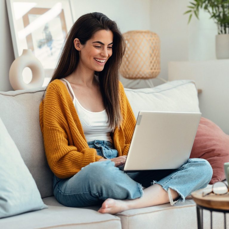 Photo: female smiling at laptop screen while having a coaching session