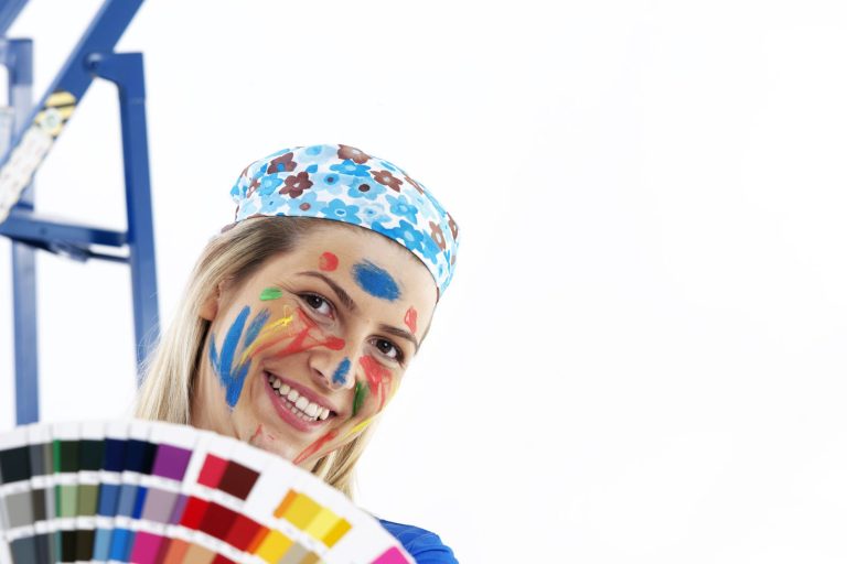 Photo: female with face covered in different colours of paint. Making a mess of the job.